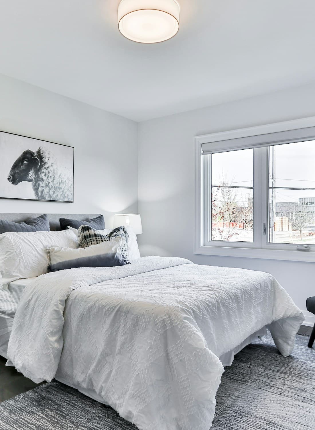 Minimal bedroom in pale plaster with a single artwork